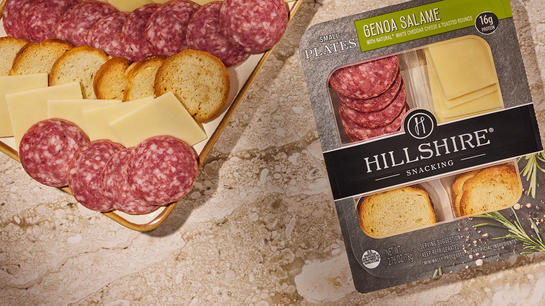 Salame, cheese, and crackers on a wooded board